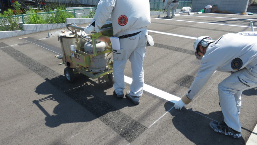 駐車場のラインを新しい車室幅に合わせて再施工中